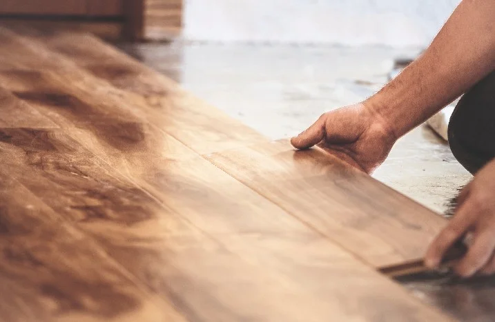 Person verlegt Holzdielen